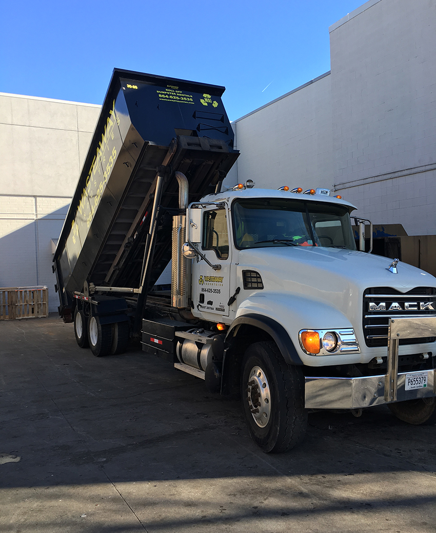 Carrier Truck dropping off dumpster rental.
